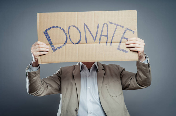 hombre sosteniendo texto de cartón una donación
 - Foto, Imagen