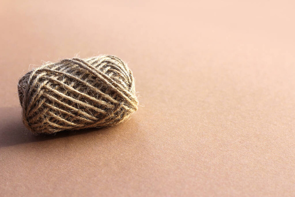 Jute rope roll on brown background. Beige round skein of jute thread close-up. Ball of twine - Photo, Image
