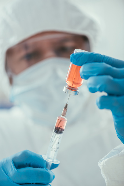 selective focus of biochemist taking medicine with syringe in laboratory - Фото, изображение