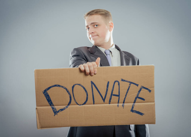 man holding Cardboard text a donate - Foto, Bild