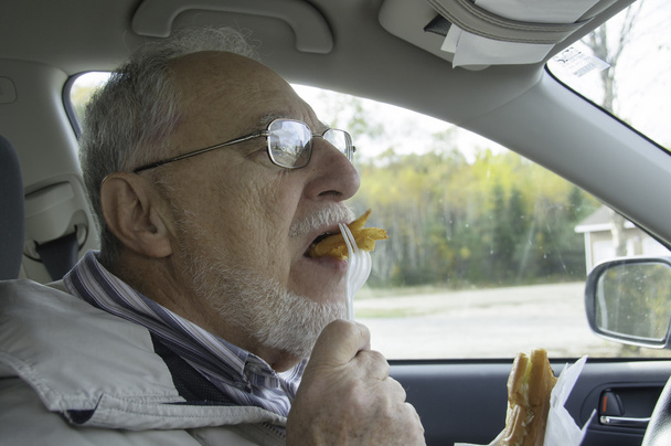 uomo anziano con viso espressivo mangiare fast food
 - Foto, immagini