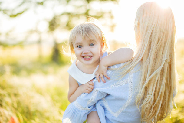 Happy young mother with daughter outdoors in summer park. - Foto, Imagem