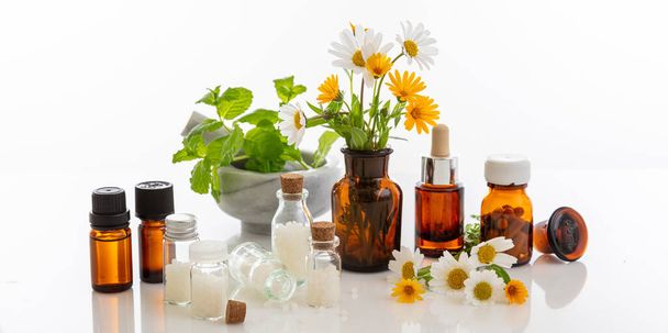Alternatív gyógynövény. Üveg orvosi palackok és friss vadvirágok és gyógynövények elszigetelt fehér háttér. Aromaterápia, Homeopátia természetes termékek - Fotó, kép