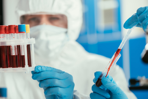 enfoque selectivo de los bioquímicos que sostienen tubos de ensayo con muestras de sangre
 - Foto, Imagen