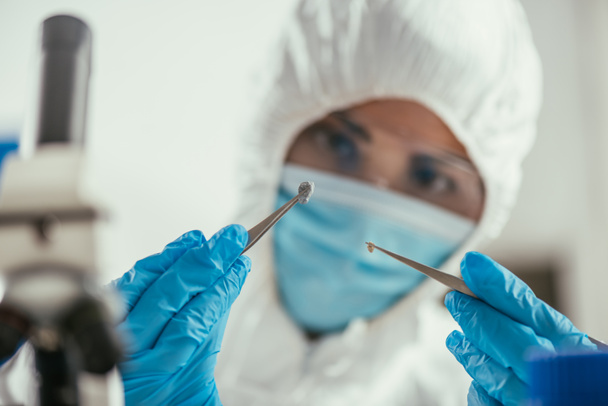 selective focus of biochemist holding small stone with tweezers - Photo, Image