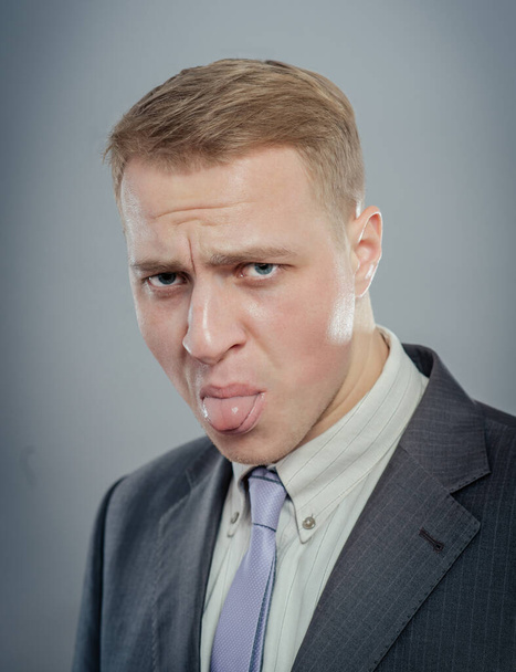 Portrait of a young businessman with tongue piercing  - Fotó, kép