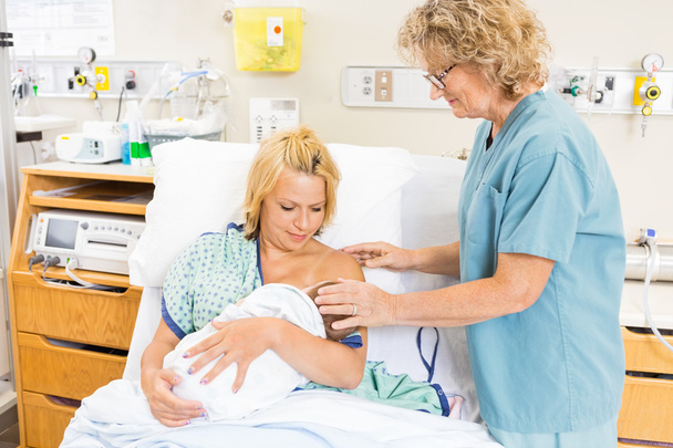 Nurse Helping Woman In Breast Feeding Baby In Hospital - Фото, изображение