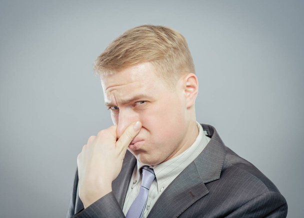 Young business man close up. Grabbing his nose with his fingers - Photo, Image