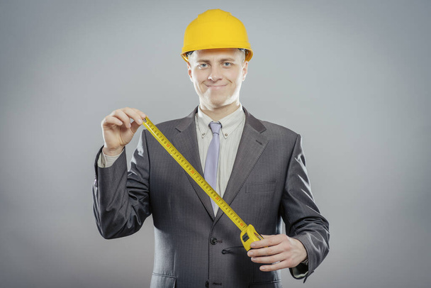 young builder with yellow tape measure - Foto, Imagem