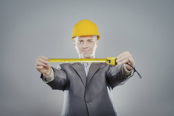 young builder with yellow tape measure - Φωτογραφία, εικόνα