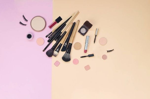 Colorful cosmetics lying on pink and yellow background. Makeup set. Flatlay background for design - Φωτογραφία, εικόνα