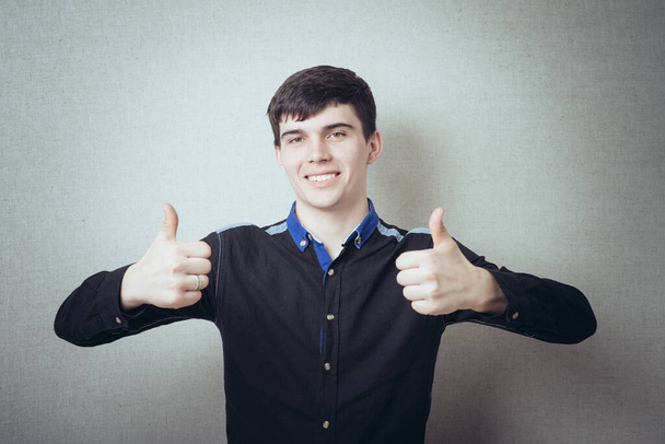 young man showing thumbs up - Φωτογραφία, εικόνα