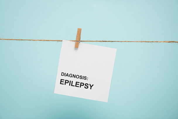 Card with diagnosis epilepsy lettering on rope with pin isolated on blue  - Foto, imagen