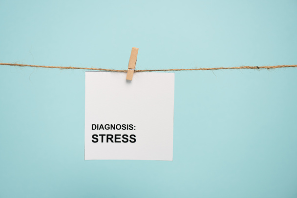 Card with diagnosis stress lettering on rope with pin isolated on blue  - Foto, immagini