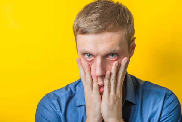 Blond young man shocked tired. Gesture. Close portrait. Isolated yellow background. photo - Fotografie, Obrázek