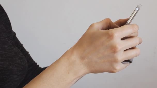 Vrouwelijke handen met behulp van mobiele telefoon scrollen - Video
