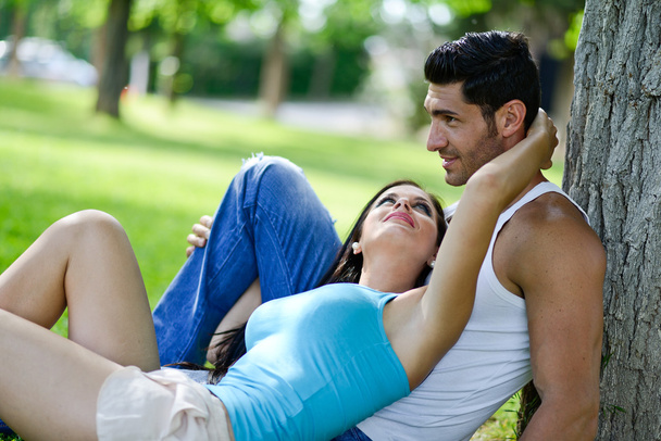 Happy smiling couple laying on green grass - Photo, Image