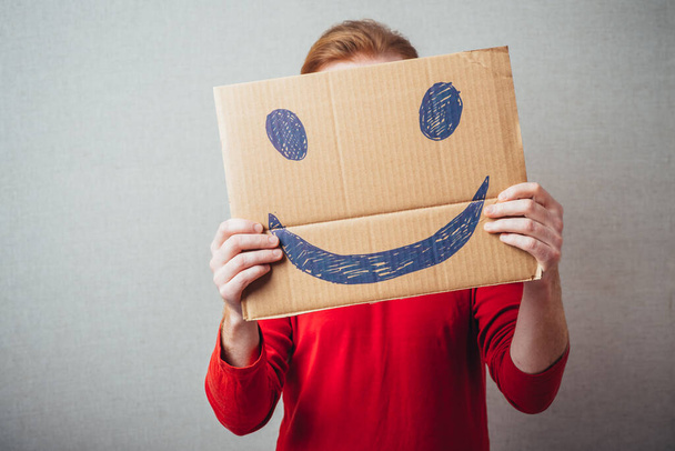 Человек с нарисованной счастливой улыбкой на листе доски
 - Фото, изображение