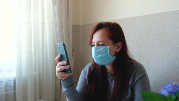 Woman takes off medical, protective mask. Quarantine is over. Breathes deeply and smiling. Girl read good news on the phone. End of the pandemic. - Filmagem, Vídeo