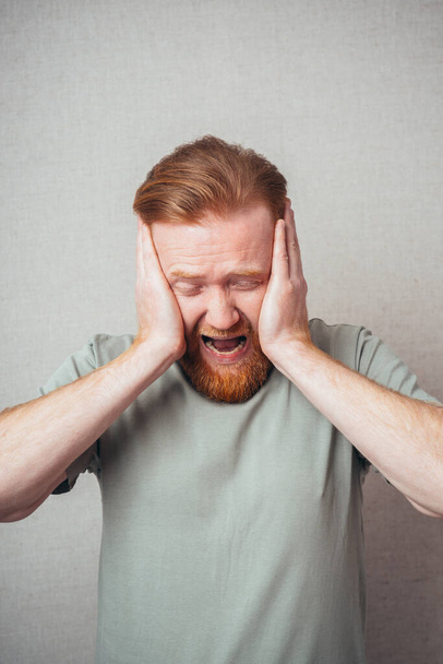 bearded man yells, holding his head - Foto, Bild