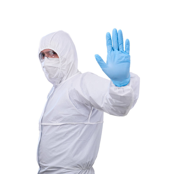 epidemiólogo masculino en traje de aislamiento antibacteriano antiepidémico desechable mono muestra gesto prohibitivo con una mano aislada sobre fondo blanco
 - Foto, imagen
