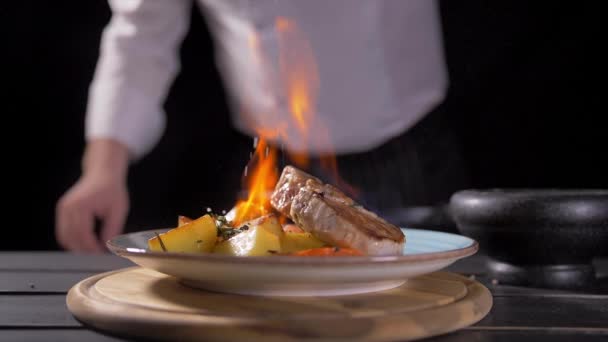 Primer plano de un chef que prepara un plato estilo Flambe en una sartén. El aceite y el alcohol se encienden con llamas abiertas. Grabación en la cámara de cine RED EPIC-W 8K Helium
. - Imágenes, Vídeo