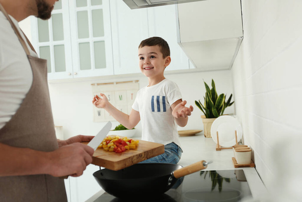 Father and son cooking together in kitchen, closeup - Photo, image