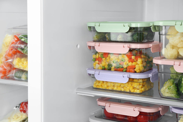 Containers with different frozen vegetables in refrigerator - Photo, Image