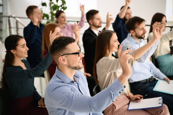 Persone che alzano le mani per porre domande durante la formazione aziendale al chiuso
 - Foto, immagini