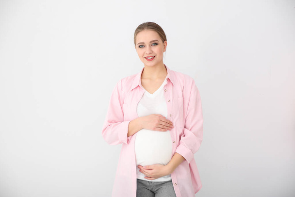 Happy young pregnant woman on white background - Foto, imagen