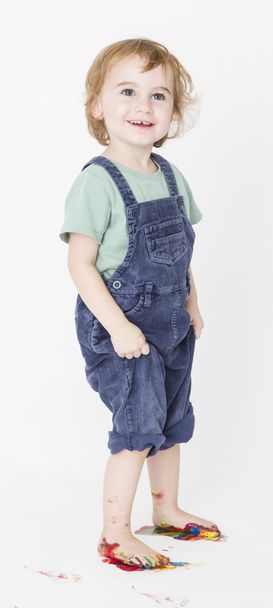 child with painted feet holding trousers - Foto, Bild