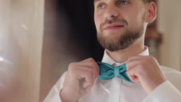 Groom adjusts bow tie. Preparing to go to the bride. Businessman. Wedding day - Footage, Video