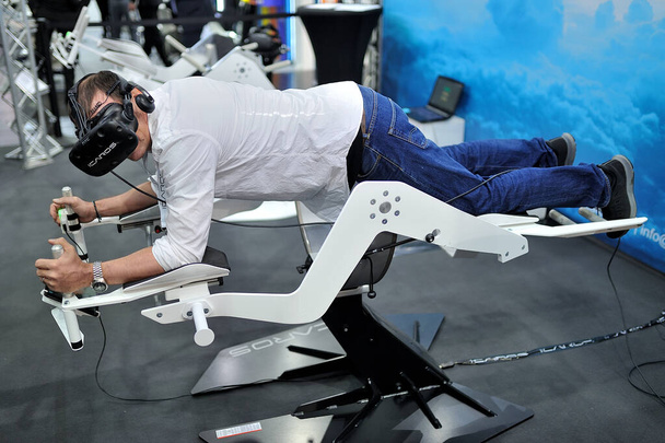 MEDICA Trade Fair, DUSSELDORF, GERMANY - NOVEMBER 2019, man is experiencing a virtual reality apparatus, robotic tools in medicine. - Foto, Imagem