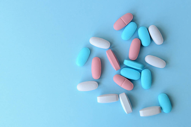 Assorted pharmaceutical medicine pills and tablets  on blue background. Copy space for text - 写真・画像
