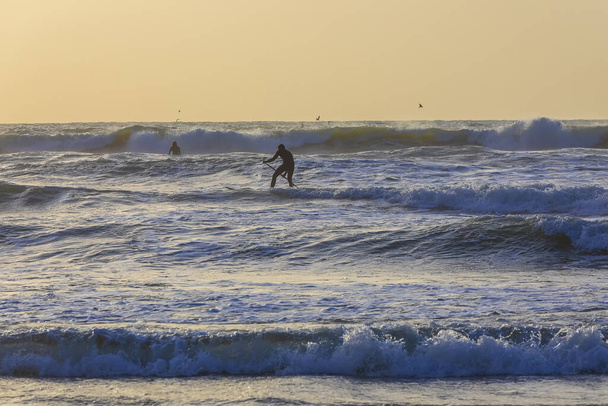 Herzliya, Izrael - 05 marca 2020: Surfer surfing na wybrzeżu Morza Śródziemnego - Zdjęcie, obraz
