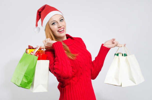 Happy young woman with Santa hat shopping for the Christmas holidays. - Foto, Imagen