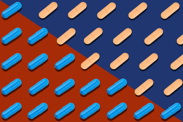Bezešvé vzor s modrými a oranžovými pilulky na červeném a modrém pozadí. Medicine health pharmacy pharmacology concept. - Fotografie, Obrázek