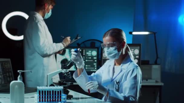 Medical scientists working in lab. Doctor teaching interns to make blood analyzing research. Laboratory tools: microscope, test tubes, equipment. Coronavirus, biotechnology, bacteriology, virology and - Footage, Video