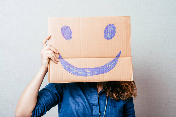 cheerful girl holding a smiley - 写真・画像
