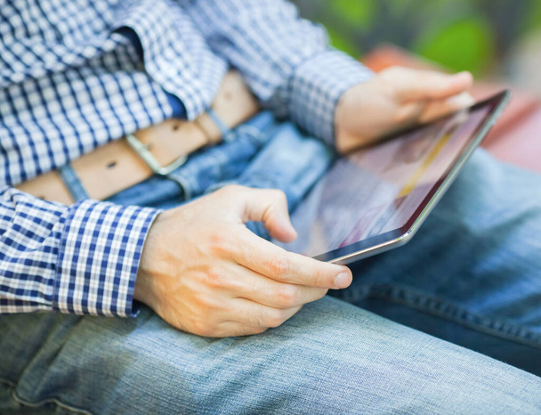 The man uses a tablet PC. Modern gadget in hand. - Fotó, kép
