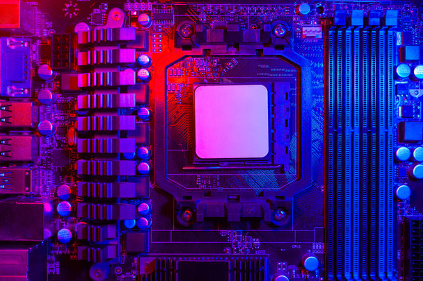 Hardware technologie concept in neon licht. Moederbord in blauw-rood licht. Computercomponent. Donkere foto. - Foto, afbeelding