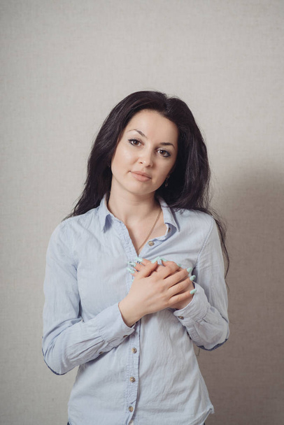 Woman hands over his chest, his heart. On a gray background. - Фото, зображення