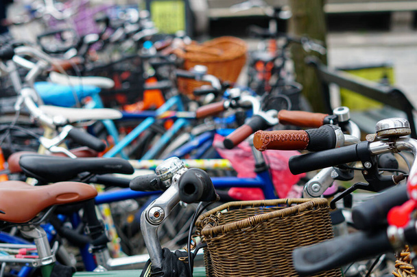 Otoparktaki farklı bisikletlerin bulanık arka planı. Amsterdam 'da park edilmiş bisikletler - Fotoğraf, Görsel