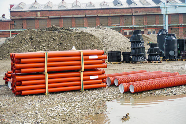 Ceramic sewer pipe stacked on construction site - Photo, Image