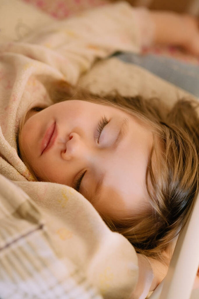 baby girl sleeping on a bed in her pajamas - Fotó, kép