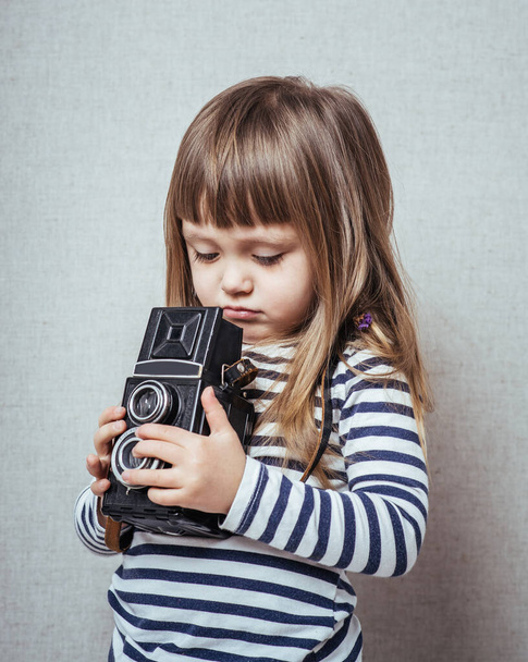 Kleines süßes Mädchen schaut Fotos in die Kamera - Foto, Bild