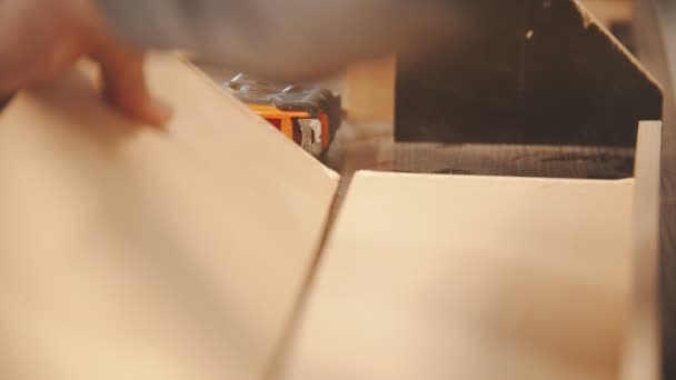 Tischlerarbeiten - Hände eines Arbeiters kleben zwei Holzteile zusammen - Filmmaterial, Video