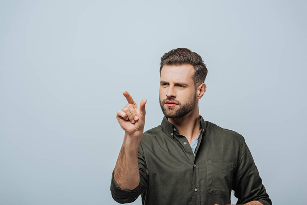 Handsome bearded man pointing with finger isolated on grey - Foto, afbeelding