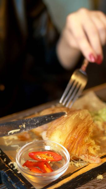 вертикальный выстрел. женщина ест картошку фри в ресторане
 - Фото, изображение