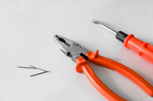 Zangen, Nägel und ein Schraubenzieher auf weißem Hintergrund. Arbeitswerkzeuge zur Reparatur. Zimmermannssatz - Foto, Bild